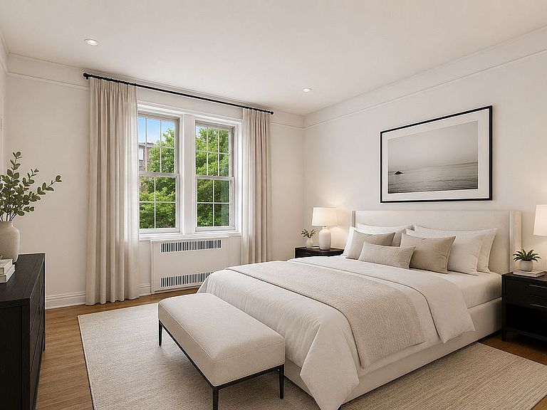The second bedroom of 360 Clinton 3T, a quiet light-filled room with a king bed, framed art, and tree views through the window